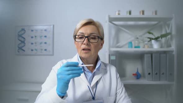 Mature Therapist Lady Measuring Patients Temperature With Electronic Thermometer