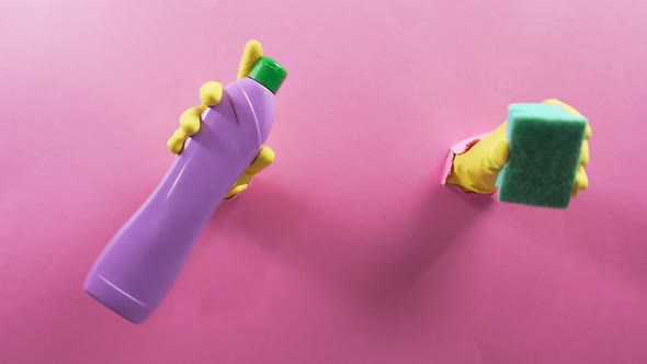 In the Hole Hands in Gloves with a Bottle of Household Chemicals and a Sponge