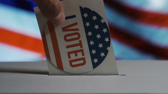 USA Elections 2020, the Hand of a Man Putting His Vote in a Ballot Box Withthe USA National Flag on alt