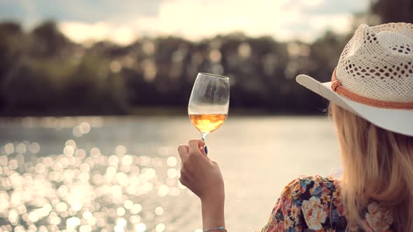 Girl Drinking Wine On Sunset.Woman Drinking White Wine.Woman Hold Glasses And Drinking Wine alt