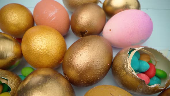 Easter Eggs Painted in Gold Color on Blue Wooden Table Close Up