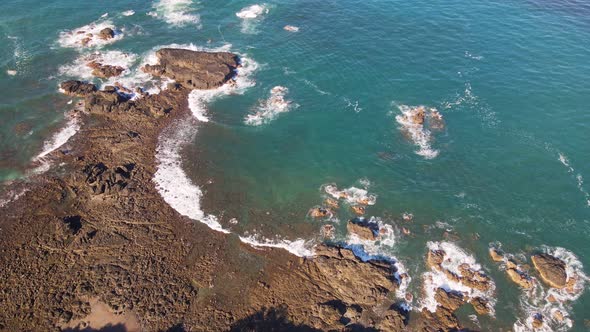 Rocky ocean shoreline near the popular seaside town of Jaco on the coast of Costa Rica. Aerial tilt alt