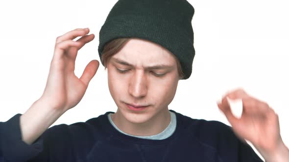 Portrait of Blueeyed Attractive Teen Guy Wearing Sweatshirt Fixing His Hat on Camera Isolated Over alt