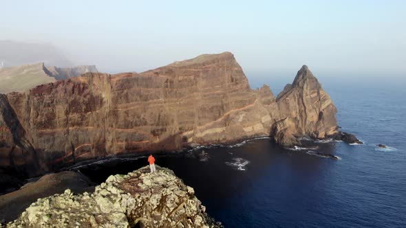 Man Standing on Top of a Cliff at Ponta de Sao Lourenco, Madeira Island, Portugal.