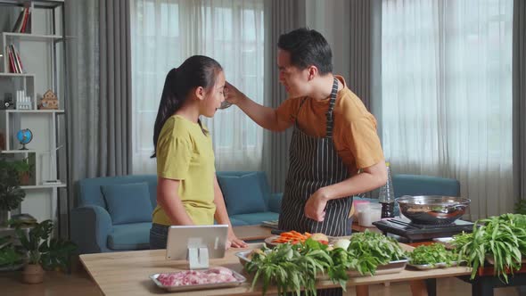 Asian Man Father And Daughter Cooking At Home, Food Tasting, Not Tasty And Laugh alt
