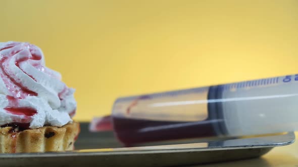 Closeup of Butter Cream Cake and Pastry Large Plastic Syringe with Berry Syrup Inside