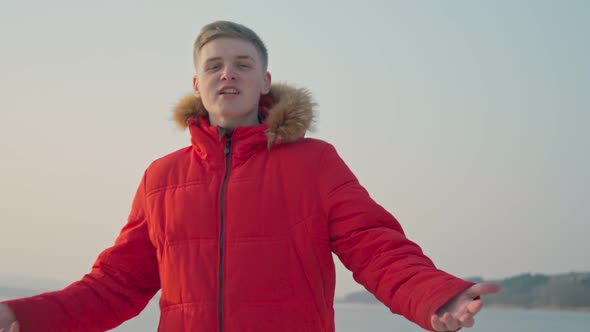A Guy of the European Race in a Red Jacket Performs a Rap Song alt