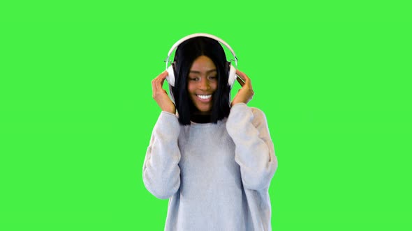 Beautiful African American Girl Enjoy Music Dance Wearing Modern Headphones and Happy Smiling on a