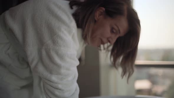 Senior woman touching water in bathtub alt