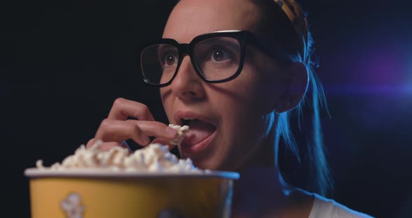 Woman watching movies and eating popcorn at the cinema, video montage