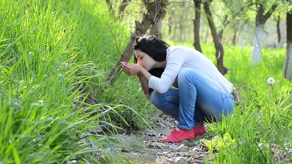 Young Girl Drinking Water from a Creek Clear 01