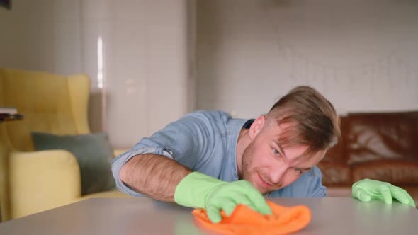 Closeup of Young Smiling Man Rubbing Table with Rag Spbas alt