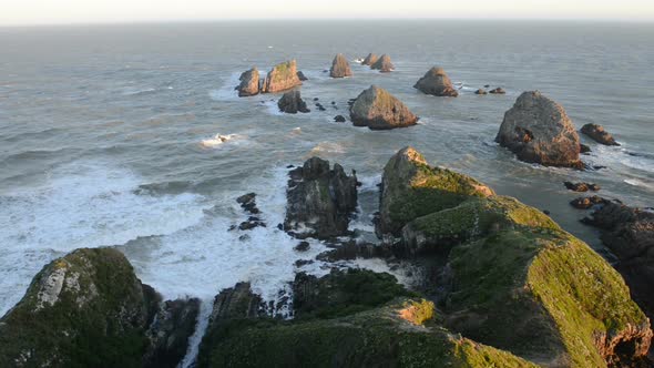 The Setting Sun Illuminates Boulders and Waves of Nugget Point