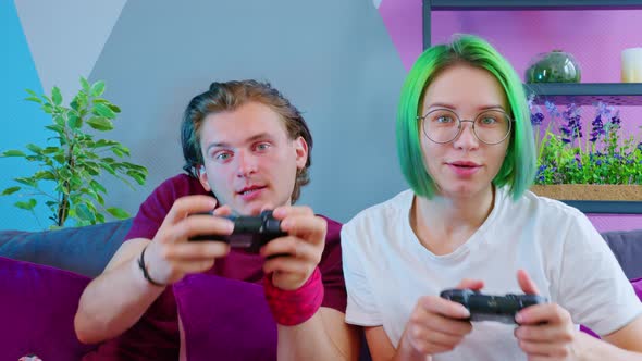 A Couple in Pajamas Playing a Game Console alt