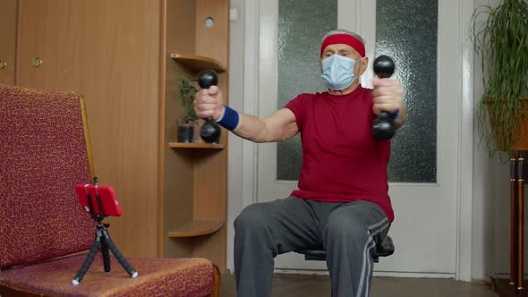 Elderly Senior Grandfather Making Weight Lifting Dumbbells Exercising During Coronavirus Lockdown alt