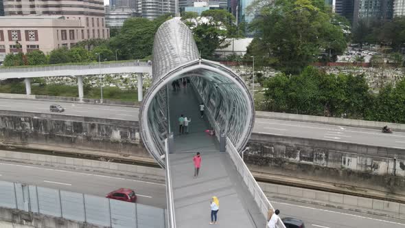 Drone flying towards bridge in Kuala Lumpur. View of graveyard and highway below the bridge.