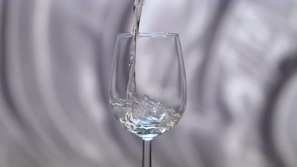 White wine being poured in a glass alt