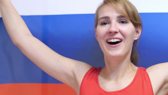 Russian Young Woman Celebrating while Holding the Flag of Russia alt