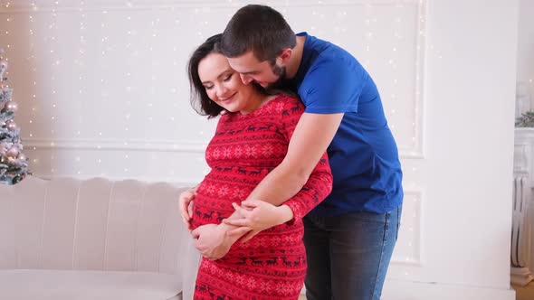 Happy Future Parents are Expecting the Birth of a Baby the Husband Strokes the Belly alt