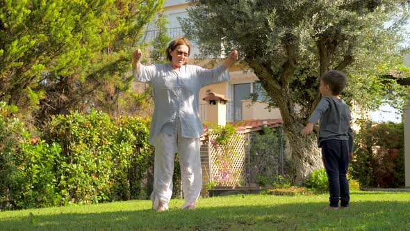 Cheerful Grandmother Having Fun with Grandson Outdoor. Little Boy Having Fun alt