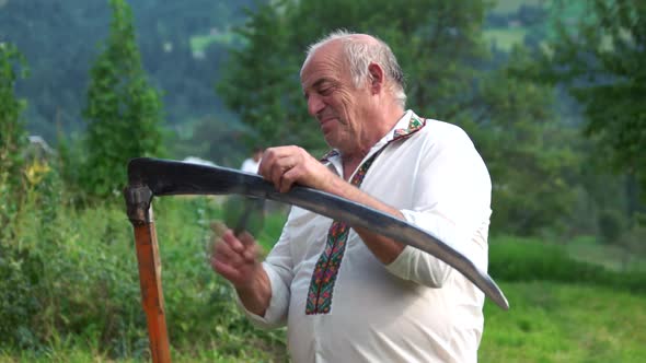 Hutsul in Traditional Ukrainian Clothes Sharpening a Scythe alt