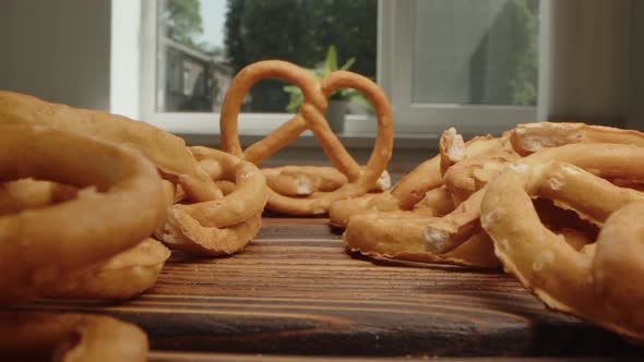 Zoom in Video of Heap of Mini Salty Pretzel Cookies on Wooden Board