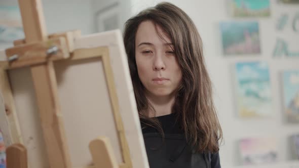 Young Woman Artist Is Working in Her Creative Studio Drawing on Canvas alt