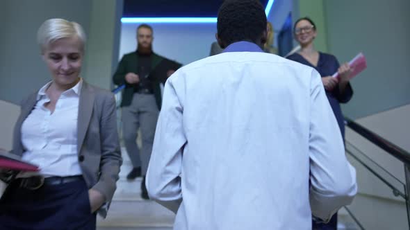 Tracking Shot African American Young Man Walking Upstairs Passing Business People in Office alt