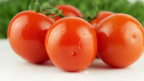Ripe natural tomatoes close-up. Organic tomato rotating on a green background Macro shot. alt