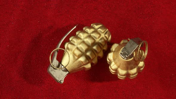 MK2 hand grenades. Two golden pineapple grenades on the red velvet cloth. alt