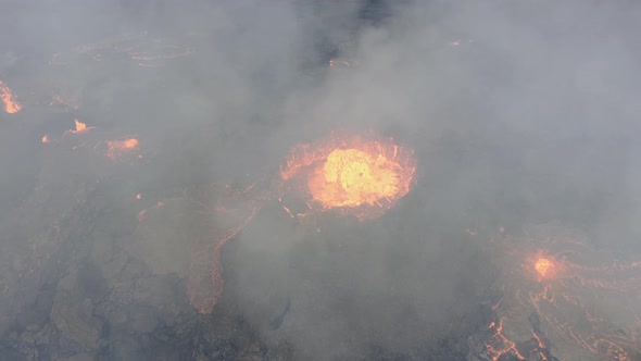 Drone engulfed in smoke over active, hot and continuous volcanic eruption with fresh flowing lava. A alt