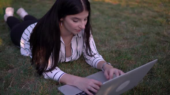 Attractive Woman Typing Laptop on Grass Outdoor Freelancer Working Online