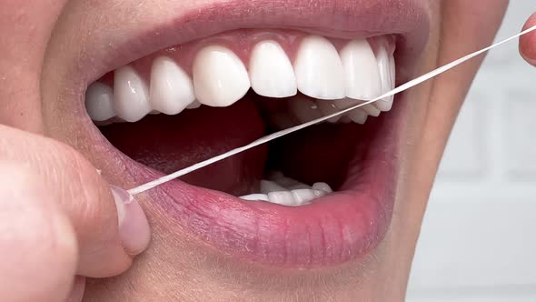 Closeup Woman Flossing Perfect White Teeth with Floss Toothcare Hygiene Teeth Cleaning Routine and alt