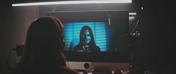 Back view of a woman reviewing the movie clips in a photo studio alt