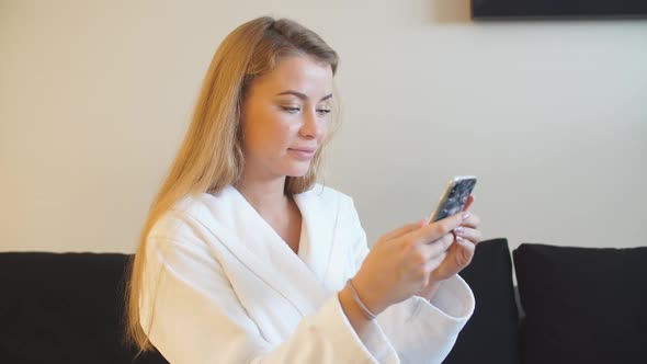 Beautiful Young Uses Smartphone To Send Photos After Spa Treatments