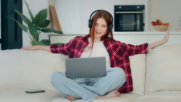 Young Carefree Girl with Laptop in Lotus Pose Listens Loud Favorite Music Enjoys Song Audio Track alt