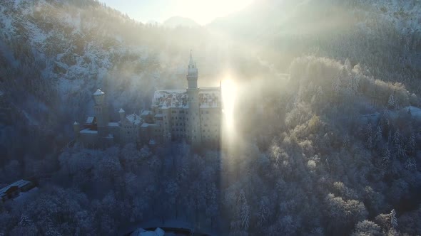 Aerial View of Neuschwanstein Castle at Sunrise in Winter Landscape.