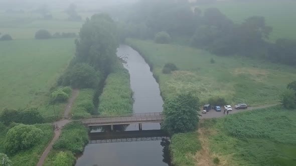 River Otter view from the sky over seen people walking on the path after having parked on the side, alt