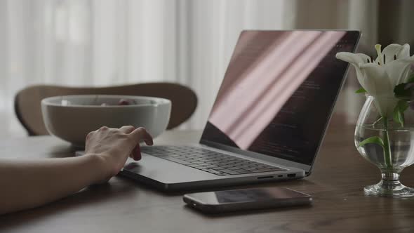 Close Up Camera Approaching a Woman Hand on a Touchpad of a Laptop Computer with Code alt