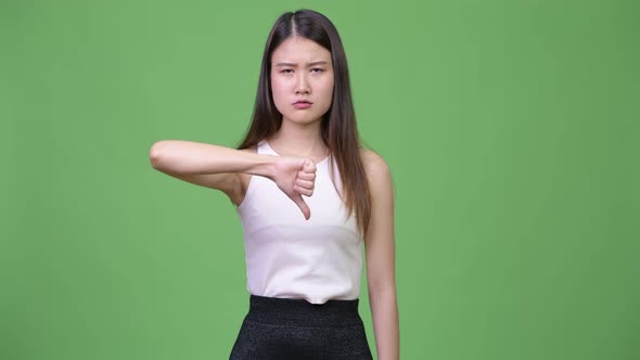 Young Beautiful Asian Businesswoman Giving Thumbs Down