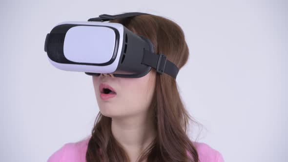 Face of Young Happy Asian Nerd Woman Using Virtual Reality Headset alt