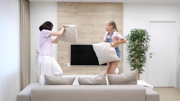 Mommy and Kid Daughter Having Pillow Fight Together Young Babysitter Nanny Playing Funny Game with