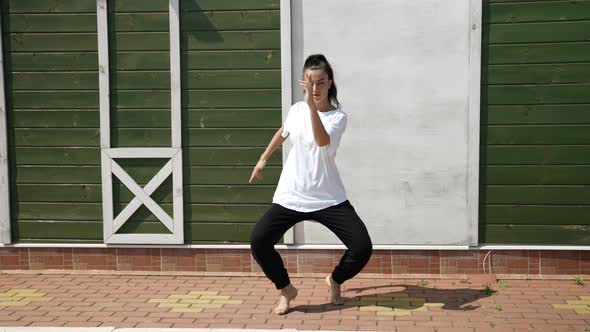 Young Woman is Dancing Hip Hop Dance Style Outdoor at Sunny Summer Day alt