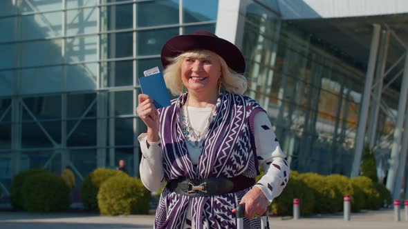 Elderly Retired Woman Tourist Near Airport Terminal Celebrating Success Winning and Goal Achievemen alt