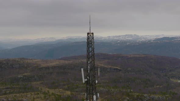 Telephone, 5G and communications tower on mountain top. View of mountain range and fjord in the back alt