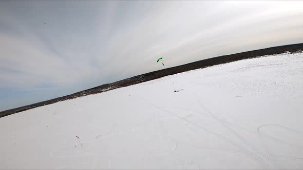 A Ramair Parachute Flying Over a Winter Field