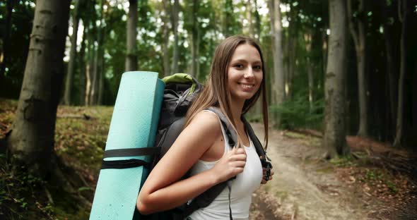 Portrait of Backpacked Woman in Forest