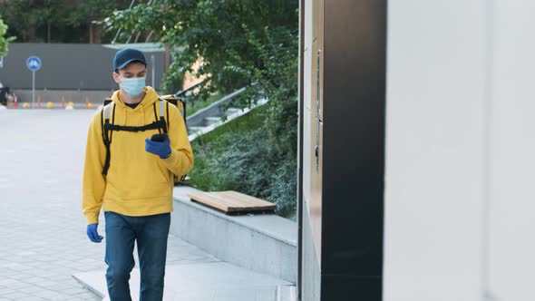 Delivery Man Wearing Protective Mask and Rubber Gloves Ringing a Door alt