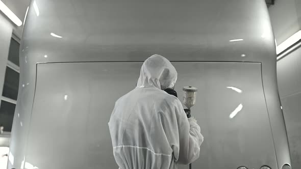 Mechanic In Bodyshop Getting Ready To Spray Paint Vehicle.  alt