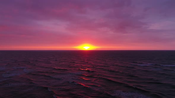 Aerial view of beautiful sunset on the sea side. Red sky with flaming sun. 